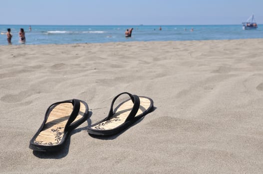 Female slippers on a beach of the mediterranean sea