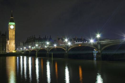 The Big Ben and Westminster Bridge at night with reflections in the river Thames