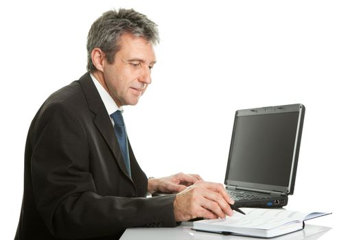 Senior business man working on laptop. Isolated on white