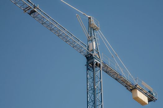 Crane on a clear blue sky background with lots of copy-space.