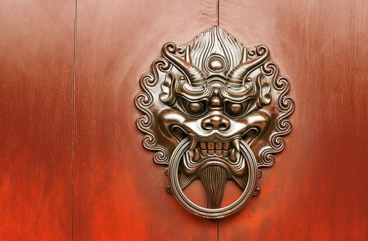Chinese decoration of bronze lion on the red wall.