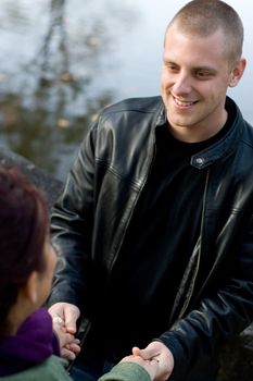 A young happy couple holding hands outdoors.