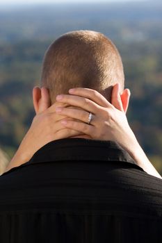 A young happy couple that just got engaged.  Shallow depth of field with focus on the diamond engagement ring.