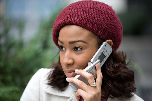 An attractive business woman talking on her cell phone in the city.