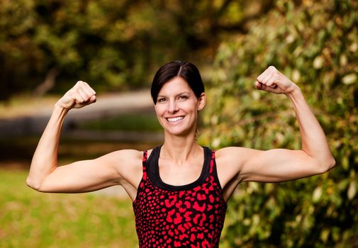 A female fitness model flexing her biceps