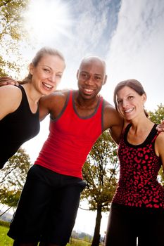 A group of frIends exercising in the park on a warm sunny day