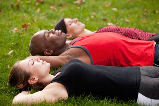 A group of people relaxing in a park after exercise