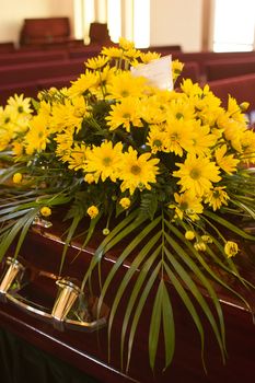 Flowers from the family on a casket at a funeral.
