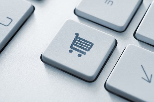 Shopping cart icon on keyboard key. Toned Image.
