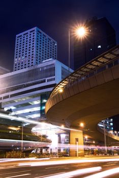 Night scenes of skyscraper with cars motion blurred light in Hong Kong.