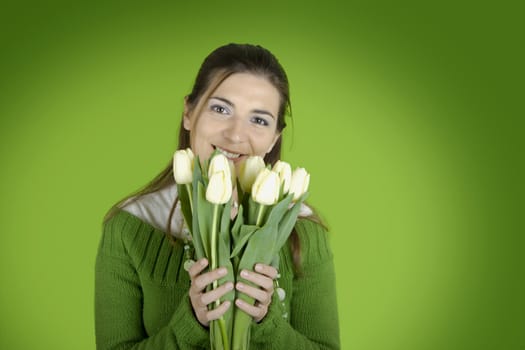 Beautiful woman with tulips on a green background