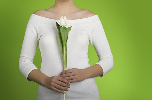 Woman with white tulips on is hands on a green background
