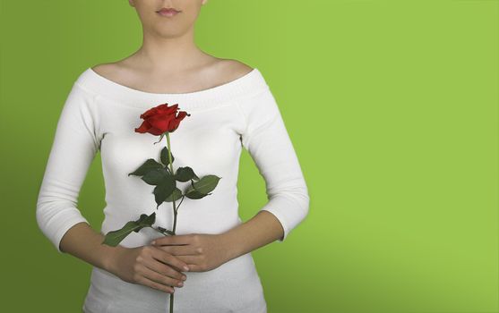 Woman with a red rose on is hands on a green background