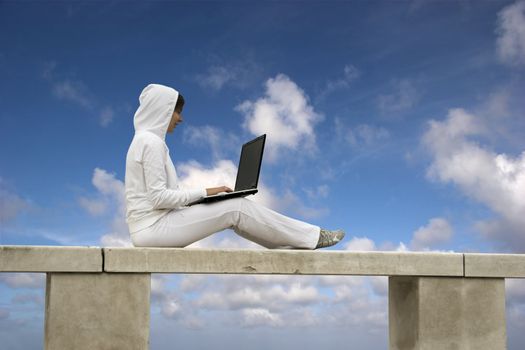 Woman working with is laptop with a beautiful blue sky