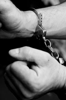 black and white photo, hands in the handcuffs