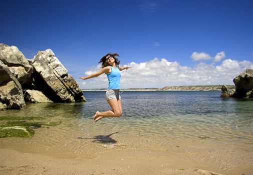 Beautiful young woman jumping on a beautiful beach