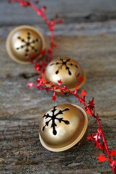 jingle bells with red star ribbon on a piece of wood textured background.