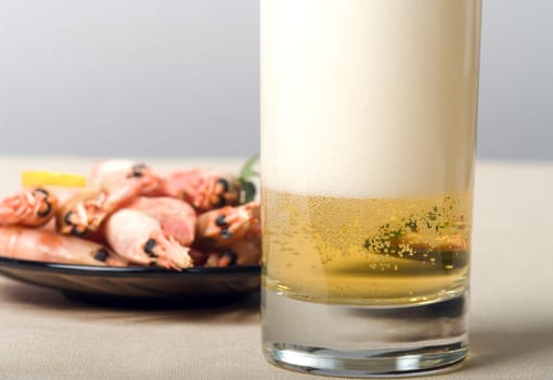 Glass of beer and plate with shrimps