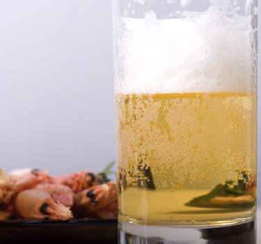 Glass with beer and boiled shrimps, a close up.