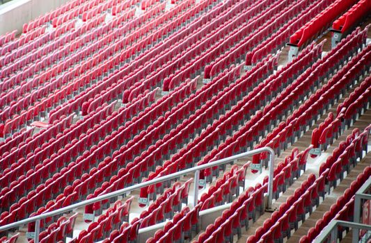 Rows of empty red seats in a football stadium