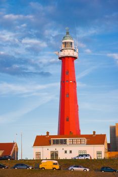 Red lighthouse in evening light with blue sky background