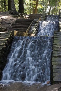 Waterfall with stairs in the forest - vertical image