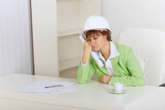 The woman the construction superintendent sits upset for a table