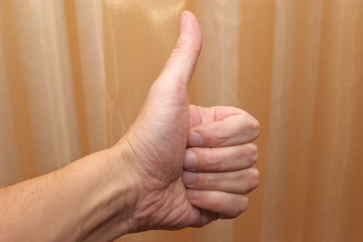 photo of the hand with raised upwards by thumb