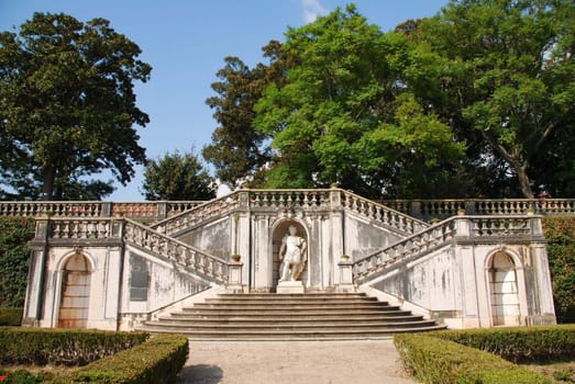 beautiful ornamental Ajuda garden with an antique staircase and statue in Lisbon, Portugal