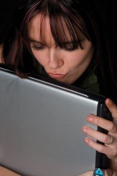 Twenty something fashion kissing her laptop