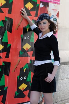 Twenty something fashion model hanging around poster hanged on a building