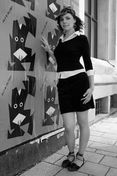 Twenty something fashion model hanging around poster hanged on a building