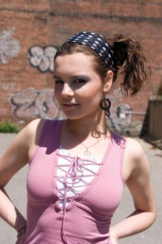 Twenty something urban fashion in front of a graffitti wall at high noon