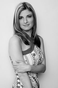 Thirty something women leaning on wall with shy smile