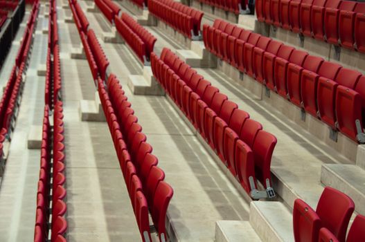 Rows of empty red seats in a football stadium