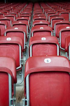 Rows of empty red seats in a football stadium