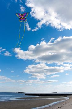 A lone flying kite at the beach on a nice day.