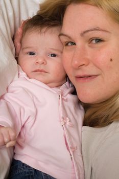 Portrait of a mother and her baby daugther being close together