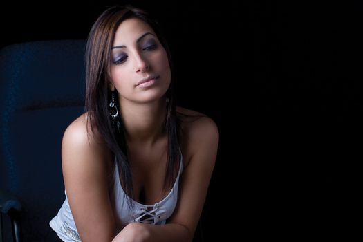 Twenty something fashion model sitting on office chair looking very calm attitude