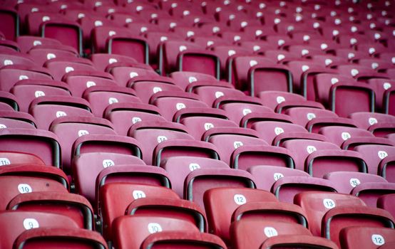 Rows of empty red seats in a football stadium