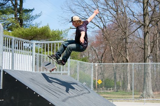 Action shot of a skateboarder on a skateboarding ramp at the skate park.