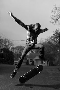 A skateboarder performing jumps or ollies on asphalt.  Slight motion blur showing the movement on the arms and legs.