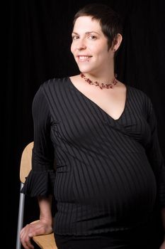 Sitting portrait of a late twenty pregnant women giving a side glance