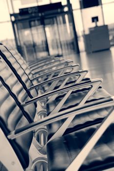 Empty chairs at the airport, entrance in the background