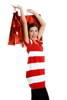 Beautiful happy young woman carrying shopping bags, isolated on white background