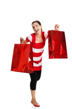 Beautiful happy young woman carrying shopping bags, isolated on white background