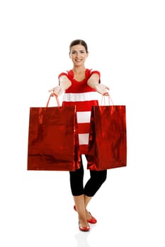 Beautiful happy young woman carrying shopping bags, isolated on white background