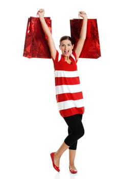 Beautiful happy young woman carrying shopping bags, isolated on white background