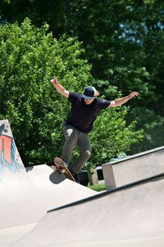 Action shot of a skateboarder going up a concrete skateboarding ramp at the skate park. Shallow depth of field.