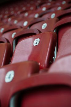 Rows of empty red seats in a football stadium